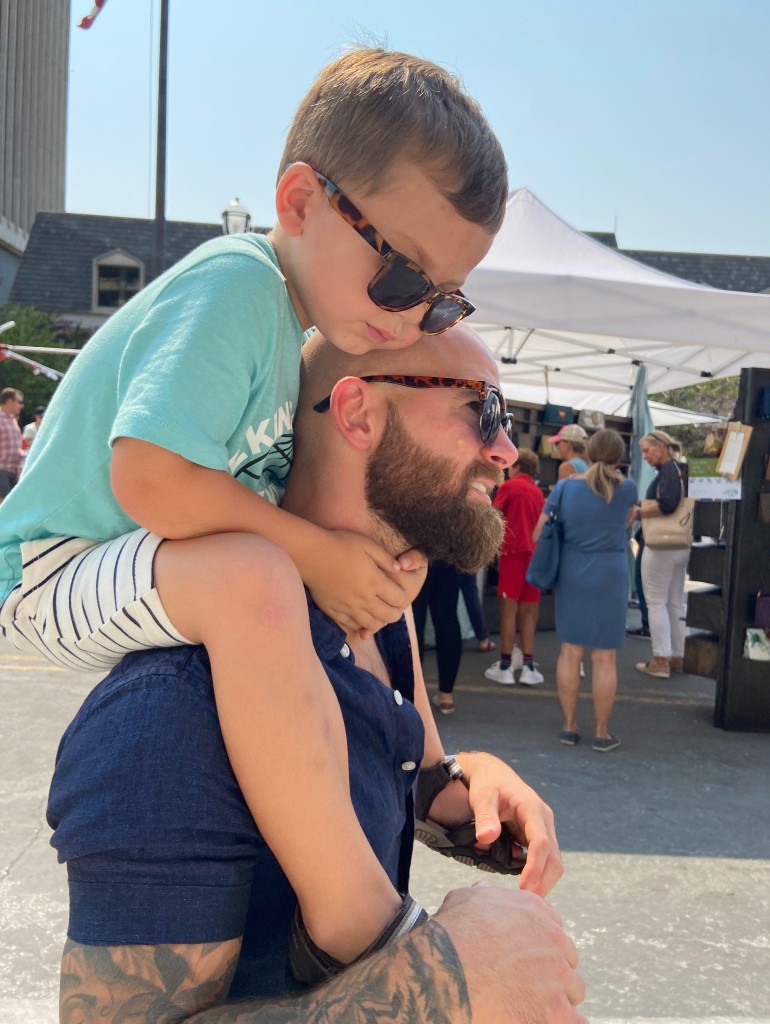 Jake Sebok with his son, on a porch in afternoon light