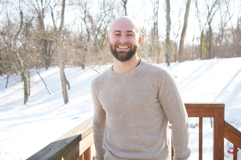 Jake Sebok smiling at the camera, in a quiet bright workspace